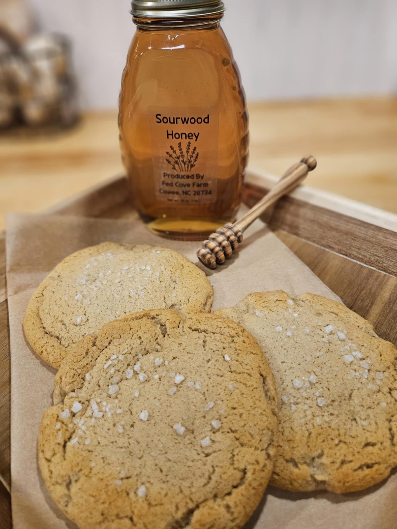 Jar of Fed Cove Farm sourwood honey with a honey dipper, served alongside sea-salt cookies